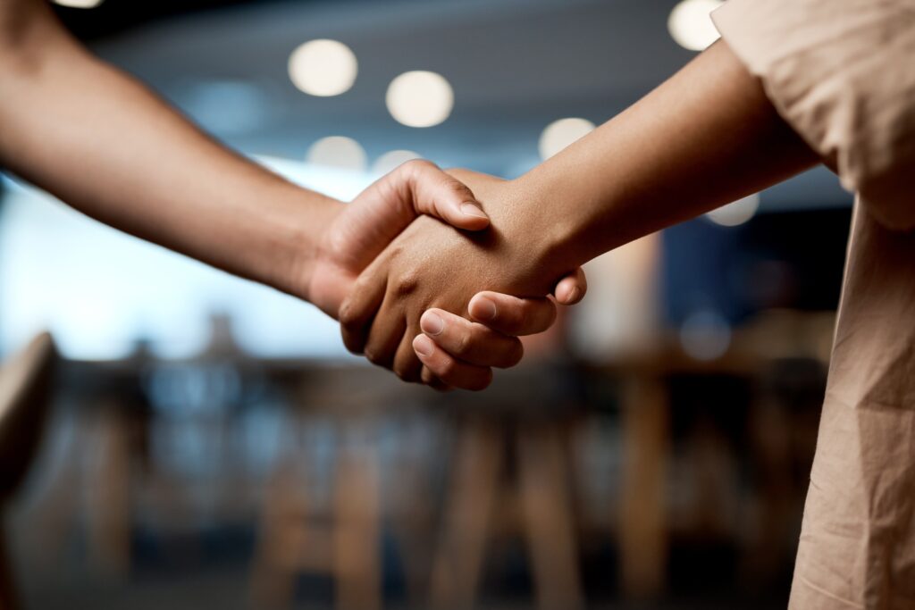 A partnership empowered by passion. Shot of two businesspeople shaking hands in a modern office.